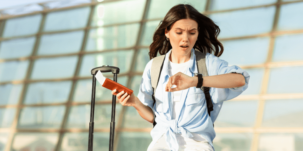 A woman stands with a suitcase in one hand and a watch on her wrist, ready for travel.