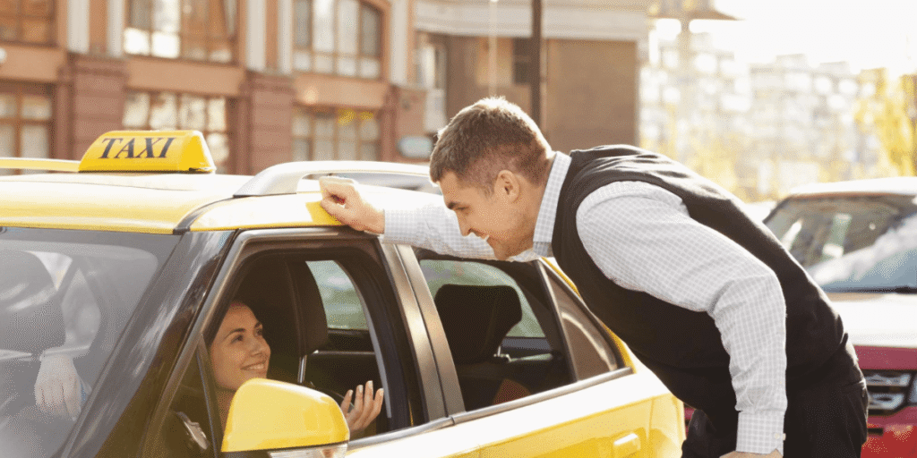 A man assists a woman as she enters a taxi, demonstrating kindness and support in a busy urban setting.