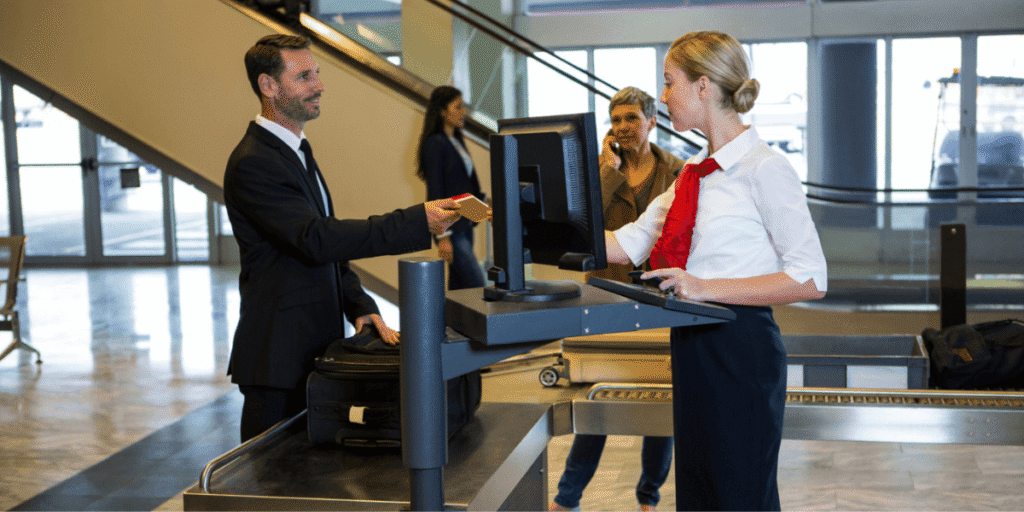 A man and woman stand together, facing a computer, engaged in discussion or collaboration.